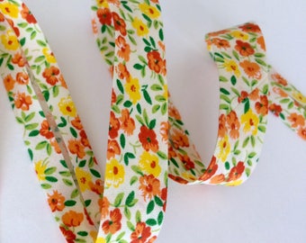 Biais pré-plié motif imprimé petites fleurs vert, orange et jaune vendu a la coupe