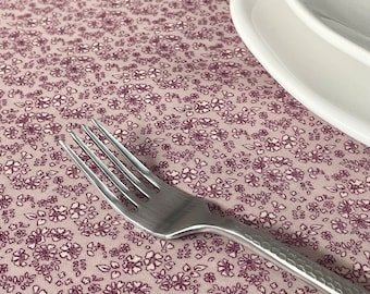 Toile cirée en coton enduit motif petites fleurs violet style liberty sur rose, vendu a la coupe par multiple de 10cm