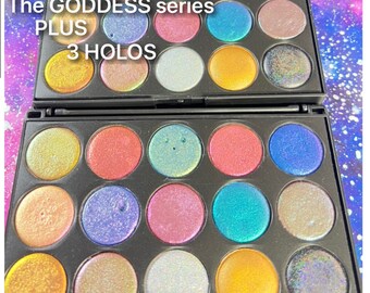 May include: A black eyeshadow palette with 18 shimmery eyeshadows. The palette is labeled "The GODDESS series PLUS 3 HOLOS" and "LIMITED EDITION".