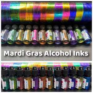 May include: A set of 16 small bottles of alcohol inks in various iridescent colors, labeled with Mardi Gras themed names like Carnival, Celebration, Epiphany, Fat Tuesday, Festival, Flambeaux, Gala, Jubilee,  and more. The bottles are arranged in two rows of eight, with the labels facing the viewer. The bottles are on a white surface. Mardi Gras Alcohol Inks is written in black text at the top of the image.