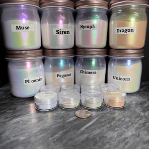 Può includere: Otto barattoli di vetro con polvere di pigmento iridescente. I barattoli sono etichettati con nomi come Muse, Siren, Nymph, Dragon, Phoenix, Pegasus, Chimera e Unicorn. Ci sono anche otto barattoli più piccoli della stessa polvere di pigmento.