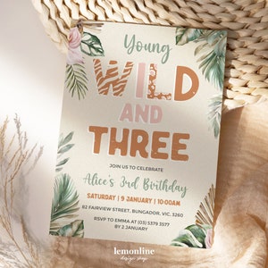 May include: A jungle-themed birthday invitation for a 3-year-old girl. The invitation features a green, brown, and pink color scheme with a watercolor design of tropical leaves and flowers. The text "Young Wild and Three" is written in a bold, playful font.