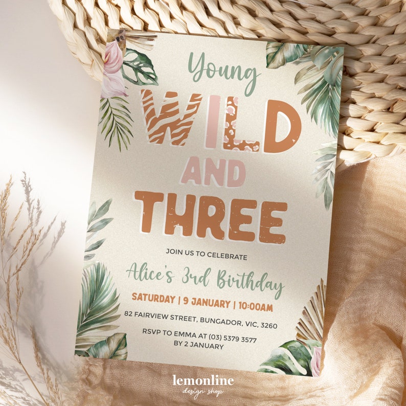 May include: A jungle-themed birthday invitation for a 3-year-old girl. The invitation features a green, brown, and pink color scheme with a watercolor design of tropical leaves and flowers. The text "Young Wild and Three" is written in a bold, playful font.