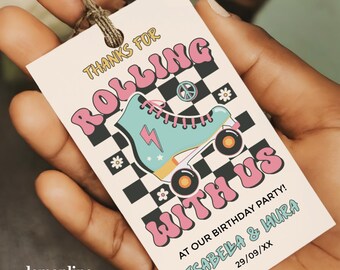 May include: A retro-style birthday party tag with the text "THANKS FOR ROLLING WITH US". It features a teal roller skate graphic with a pink lightning bolt and wheels, set against a black and white checkered background. The tag includes the names Isabella & Laura.