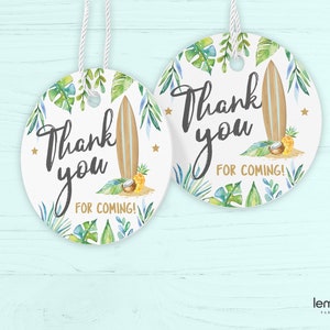 May include: Two round white thank you tags with a tropical theme. The tags feature a surfboard, pineapple, coconut, and green and blue tropical leaves. The text on the tags reads "Thank you for coming!"