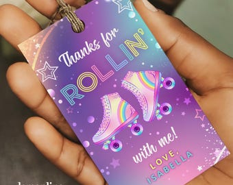 May include: Purple and blue thank you tag with a rainbow roller skate design. The text reads "Thanks for Rollin' with me! Love, Isabella".