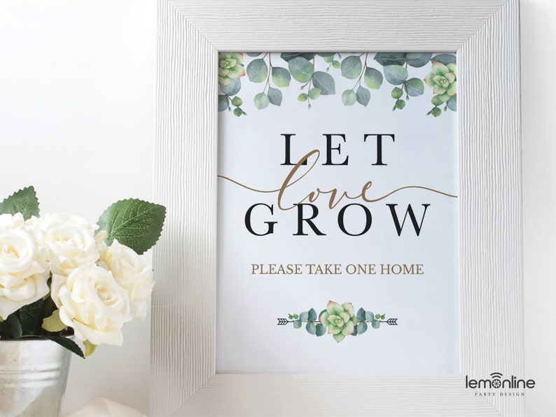 May include: White framed sign with a green and gold floral design. The sign says "Let love grow" and "Please take one home".