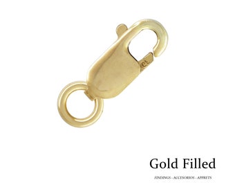 Könnte beinhalten: Ein goldgefüllter Karabinerverschluss mit federbelastetem Tor und kleinem Ring zur Befestigung. Der Verschluss hat eine warme, gelb-goldene Farbe und ist für die Schmuckherstellung bestimmt. Der Text "Gold Filled" steht darunter.