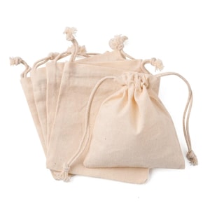 May include: A collection of beige drawstring bags made of a natural fabric. The bags are in various sizes, with a few open and others closed with a drawstring. The bags are arranged on a white background.