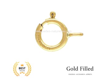 Pode incluir: Fecho de argola de salto em ouro preenchido para a fabricação de joias. A argola é redonda e tem um pequeno laço lateral. A argola é marcada com o texto "14KGF".