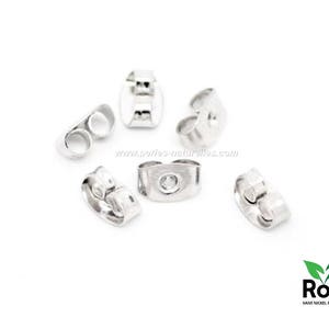 Puede incluir: Seis respaldos de pendientes de plata, también conocidos como tapones de pendientes, se muestran sobre una superficie blanca. Los respaldos de pendientes están hechos de metal y tienen un pequeño agujero en el centro. Están diseñados para ser utilizados con pendientes de poste para mantenerlos en su lugar.