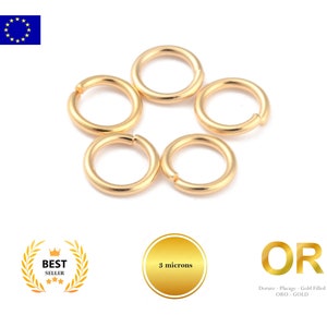 Può includere: Cinque anelli di salto in oro, ognuno con un diametro di circa 6 mm. Gli anelli sono disposti in cerchio su uno sfondo bianco. Il testo "OR" è visibile nell'angolo in basso a destra dell'immagine, insieme al testo "Dorure - Placage - Gold Filled ORO - GOLD".