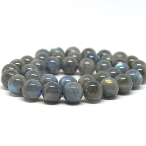 Peut inclure: Un brin de perles rondes en labradorite grise avec des reflets irisés bleus et verts.