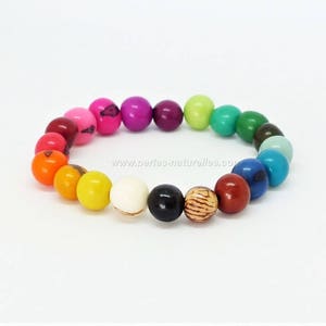 May include: A colourful bracelet made of round wooden beads in a rainbow pattern. The beads are strung on a clear elastic cord. The bracelet is approximately 18 cm in length.