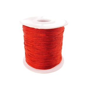 May include: A spool of bright red thread wound on a white plastic bobbin.