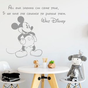 K&ouml;nnte beinhalten: Ein grauer Mickey Mouse Wandaufkleber mit dem Zitat "All our dreams can come true, if we have the courage to pursue them. Walt Disney" an einer wei&szlig;en Wand.