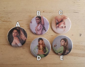 May include: Five round buttons with different images of a woman with long hair. The buttons are white with a silver rim. The images are in color and show the woman in different poses and outfits.
