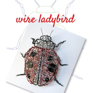 Puede incluir: Una escultura de mariquita de alambre con cuerpo rojo y negro, detallada con acentos en espiral. La imagen incluye el texto "TUTORIAL TEMPLATE" y "wire ladybird". La mariquita está sobre una superficie blanca, con un contorno esbozado.