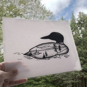 May include: A black and white illustration of a loon, with a landscape scene inside its body. The landscape includes trees, mountains, and a small boat. The artwork is signed and dated 2019.