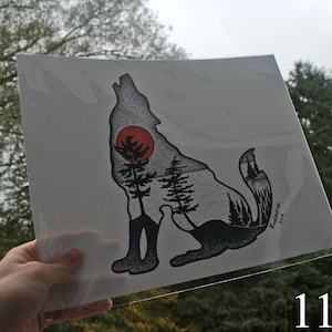 May include: Black and white illustration of a wolf howling at a red sun. The wolf is made up of trees and a forest scene. The print is 11x14 inches.
