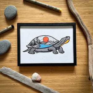 May include: A framed illustration of a turtle with a landscape scene inside its shell. The scene includes a red sun, trees, and a body of water. The turtle is grey with yellow accents.