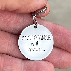 May include: Silver keychain with a round tag that reads "ACCEPTANCE is the answer..."