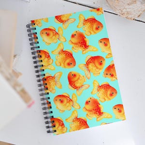 Lindo cuaderno espiral de media letra con puntos de peces dorados