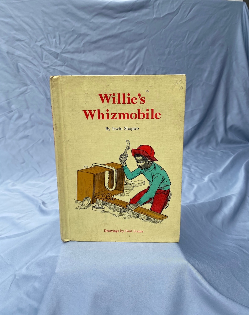 Puede incluir: Un libro infantil vintage titulado "Willie's Whizmobile" de Irwin Shapiro. La portada presenta una ilustraci&oacute;n colorida de un ni&ntilde;o peque&ntilde;o con un sombrero rojo y una camisa azul, construyendo un coche de juguete de madera.