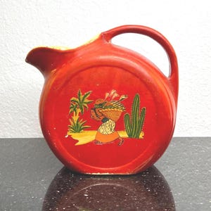 Antique Red Fiesta Style Pitcher Decorated With A Woman, Cactus, Palm tree
