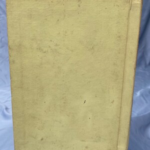 Puede incluir: Un libro vintage con una cubierta amarilla y un lomo con una franja roja. El libro est&aacute; ligeramente desgastado y tiene algunas manchas en la cubierta.