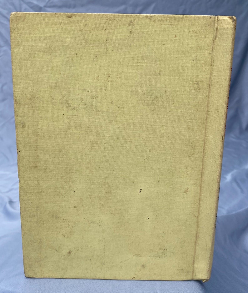 Puede incluir: Un libro vintage con una cubierta amarilla y un lomo con una franja roja. El libro est&aacute; ligeramente desgastado y tiene algunas manchas en la cubierta.