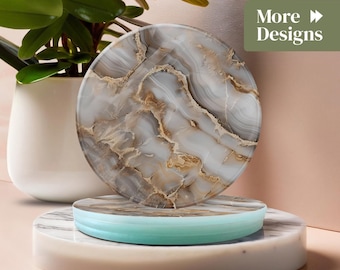 May include: A round coaster with a marble design in shades of gray and brown, resting on a marble and turquoise stand. The image also features a potted plant and the text "More Designs".