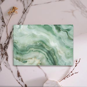 Può includere: Vassoio decorativo rettangolare con un design a marmo verde e bianco. Il vassoio presenta motivi a spirale di verde chiaro e scuro, creando un aspetto naturale simile alla pietra. È un oggetto decorativo.