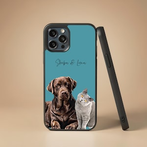 Pode incluir: Uma capa de telemóvel preta com fundo azul-petróleo, apresentando uma ilustração de um cão Labrador castanho e um gato cinzento. O texto Sheba & Luna está impresso em letra cursiva preta acima dos animais. A capa tem uma abertura para câmara tripla.