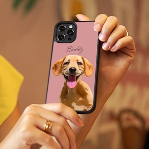 May include: A pink phone case with a black border and a cartoon image of a golden retriever puppy with the name "Buddy" printed on the case.
