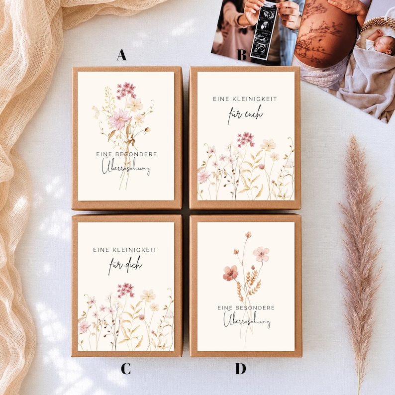 Puede incluir: Cuatro cajas de regalo rectangulares de cart&oacute;n con etiquetas blancas que presentan ilustraciones de flores silvestres en acuarela y texto en alem&aacute;n. Las etiquetas A y D dicen EINE BESONDERE &Uuml;berraschung, mientras que B y C dicen EINE KLEINIGKEIT f&uuml;r euch o f&uuml;r dich.
