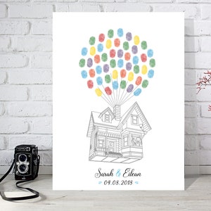 Peut inclure: Une affiche imprimable blanche avec un contour noir et blanc d'une maison avec des ballons. Les ballons sont remplis d'empreintes digitales colorées. Le texte "Sarah & Elean 04.08.2018" est en bas de l'affiche.