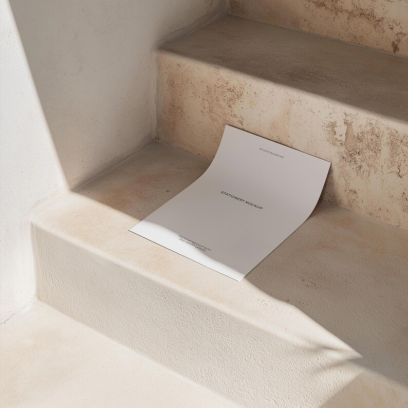 Puede incluir: Una hoja de papel blanca con el texto "Stationery Mockup" impreso en ella, que se encuentra sobre un conjunto de escaleras de hormig&oacute;n.