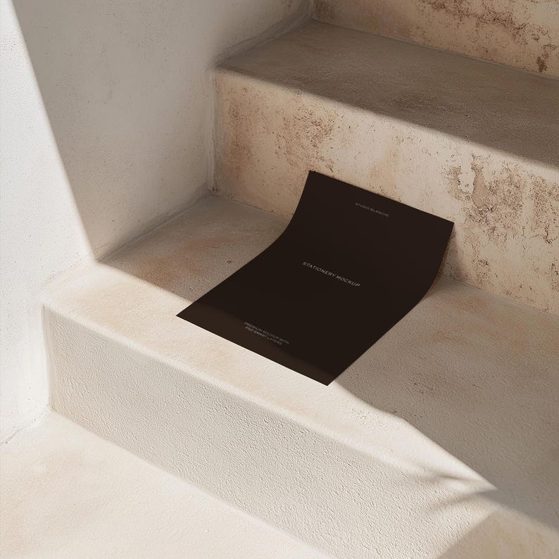 Puede incluir: Una tarjeta de maqueta de papeler&iacute;a negra en un conjunto de escaleras de hormig&oacute;n. La tarjeta est&aacute; en blanco y tiene el texto "Stationery Mockup" impreso en ella.