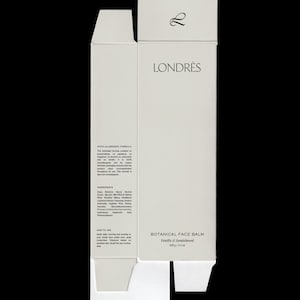 May include: A white, unfolded product box for Londrès Botanical Face Balm. The box features the brand name, product details, and ingredient information. The balm is vanilla and sandalwood scented, with a net weight of 100g / 3.5 oz.