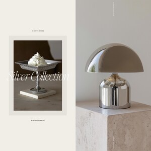 May include: A silver serving dish with a decorative design and a small amount of whipped cream on top. The dish is on a white marble surface. The text "Silver Collection" is written in a decorative font below the dish. The text "By Studio Blanche" is written below the image.