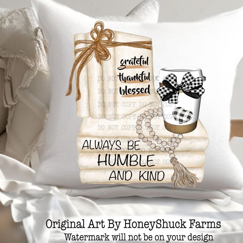 May include: A white throw pillow featuring a graphic illustration of a stack of books tied with a brown string, a coffee cup with a black and white buffalo check bow and heart, and a wooden bead garland with a tassel. Text reads grateful thankful blessed and ALWAYS BE HUMBLE AND KIND.