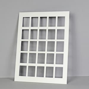 Puede incluir: Panel blanco de forma cuadrada con una cuadr&iacute;cula de 30 recortes cuadrados. El panel est&aacute; hecho de un material grueso y r&iacute;gido.