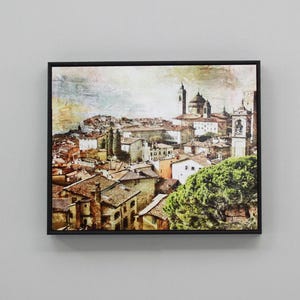 May include: A vintage-style painting of a European city with a church in the background. The painting is done in warm colours with a textured effect.
