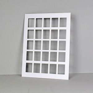 Puede incluir: Tarjeta blanca de forma cuadrada con una cuadr&iacute;cula de 36 recortes cuadrados. La tarjeta est&aacute; colocada plana sobre una superficie gris.