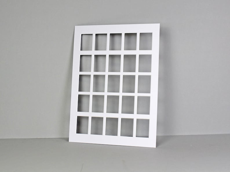 Puede incluir: Tarjeta blanca de forma cuadrada con una cuadr&iacute;cula de 36 recortes cuadrados. La tarjeta est&aacute; colocada plana sobre una superficie gris.