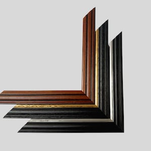 May include: Three L-shaped picture frame corner samples stacked vertically. The top frame is a reddish-brown wood grain. The middle frame is black with a thin gold inner edge. The bottom frame is black with a thin silver inner edge.