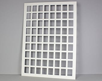 Puede incluir: Hoja de metal blanca con un patrón de rejilla de recortes cuadrados. La hoja mide aproximadamente 30 cm por 40 cm.