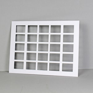 Puede incluir: Marco rectangular blanco con 25 aberturas cuadradas. El marco est&aacute; hecho de un material grueso y resistente y tiene un acabado liso y mate.