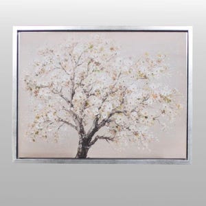May include: A framed painting of a blossoming tree. The artwork features a dark tree trunk and branches, with white and light yellow flowers. The background is a soft, neutral colour, and the frame is silver.
